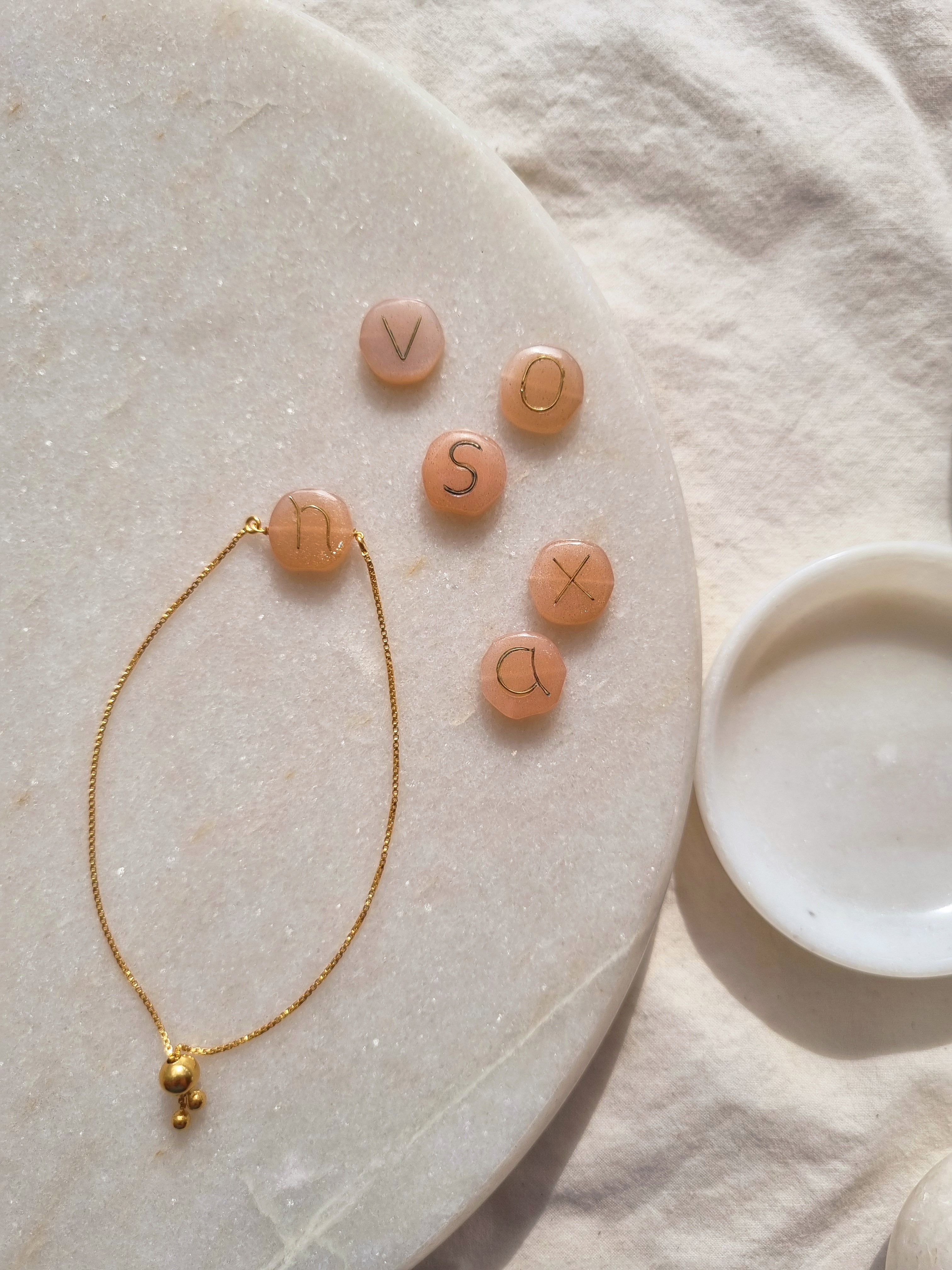 madana- Peach Moonstone Pebble with Embossed Initial Bracelet